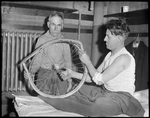 Reggie McNamara examines damaged wheel after being thrown at Boston garden