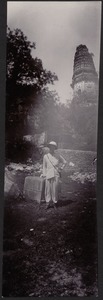 Unidentified young man (western) posing amid ancient ruins; temple in background